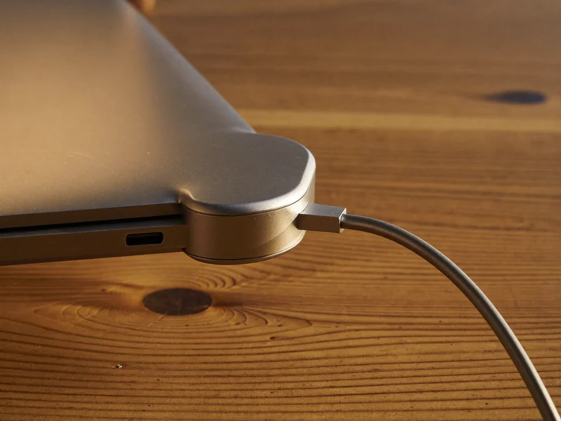 Aluminiowy hub USB-C na krawędzi laptopa z podłączonym kablem